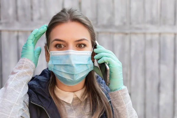 Νεαρή Ελκυστική Γυναίκα Που Φοράει Χειρουργική Μάσκα Και Γάντια Μιλάει — Φωτογραφία Αρχείου