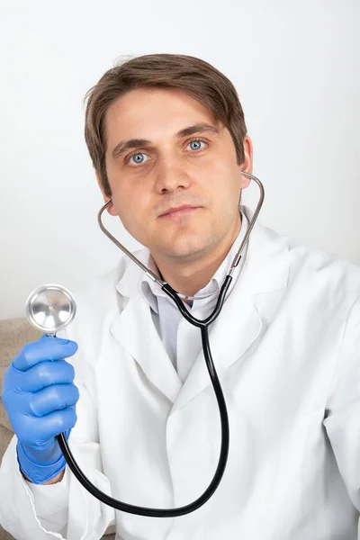 办公室里戴听诊器的年轻英俊男医生的画像 — 图库照片