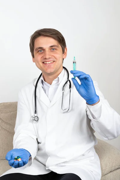 Confiado Joven Doctor Varón Sentado Sofá Oficina Sosteniendo Medicamentos Inyección —  Fotos de Stock