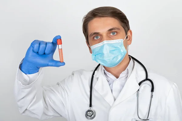 Médico Varón Joven Con Máscara Quirúrgica Guantes Sosteniendo Una Muestra —  Fotos de Stock