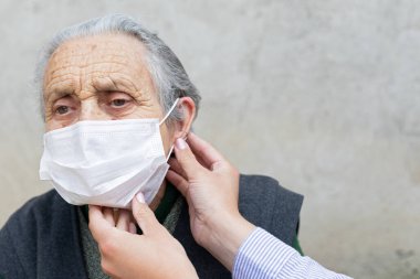 Covid-19 salgınından dolayı koruyucu maske takan yaşlı kadın portresi