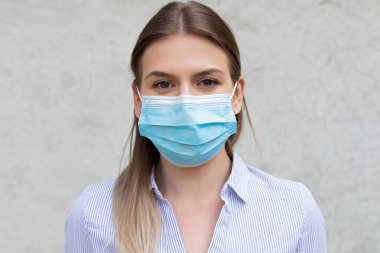 Cerrahi maske takan genç beyaz kadın - koronavirüs karantinası