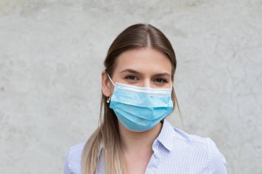 Cerrahi maske takan genç beyaz kadın - koronavirüs karantinası