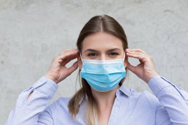 Cerrahi maske takan genç beyaz kadın - koronavirüs karantinası