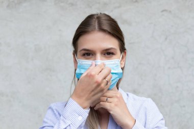 Cerrahi maske takan genç beyaz kadın - koronavirüs karantinası