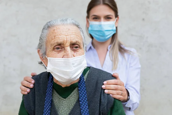 Retrato Cuidador Amigable Posando Con Una Anciana Enferma Usando Máscara — Foto de Stock