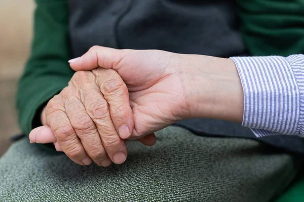 Närbild Vårdnadshavare Som Håller Äldre Kvinnas Skrynkliga Händer — Stockfoto