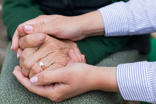 Nahaufnahme Eines Pflegers Der Die Faltigen Hände Einer Seniorin Hält Stockfoto