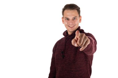 Yakışıklı genç adam izole edilmiş arka planda kameraya gülümsüyor, parmağıyla işaret ediyor.