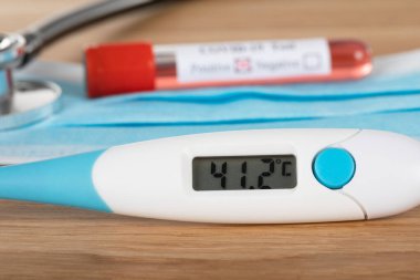 Tahta arka planda pozitif covid-19 kan testi ve tıbbi malzemeler, tedavi, maske ve eldivenlerin fotoğrafını çek