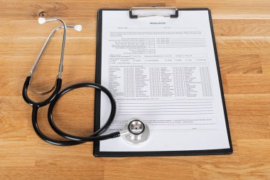 Tahta masadaki hasta hasta ve steteskop kayıtları.