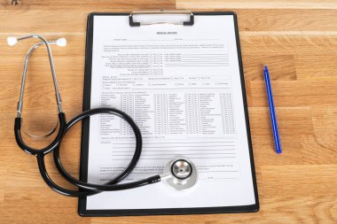 Tahta masadaki hasta hasta ve steteskop kayıtları.