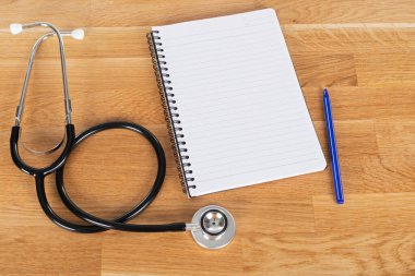 Tahta masadaki hasta hasta ve steteskop kayıtları.