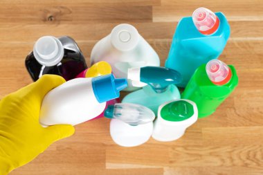 Ahşap arka planda temizlik malzemeleri ve hijyenik ekipmanların üst görüntüsü