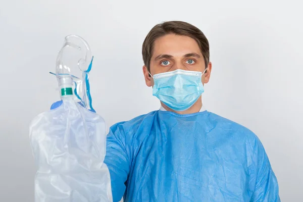 Ung Manlig Läkare Bär Skyddande Uniform Håller Syrgasmask Isolerad Bakgrund — Stockfoto