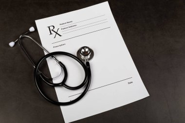 Koyu arkaplanda hastanın form ve steteskop doldurma resmi