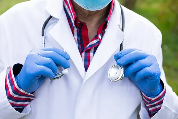 Göğsünün Önünde Eldiven Tutan Stetoskop Tutan Yaşlı Bir Erkek Doktorun — Stok fotoğraf