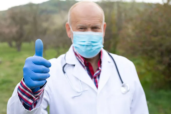 Dışarıda Kameraya Baş Parmağını Gösteren Yaşlı Bir Erkek Doktorun Portresi — Stok fotoğraf