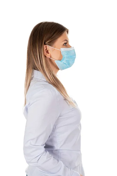 孤立した背景に外科マスクを身に着けている若い白人女性のサイドポートレート — ストック写真