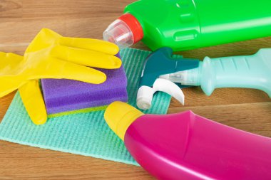 Ahşap arka planda renkli temizlik malzemeleri ve araçlarının resmi