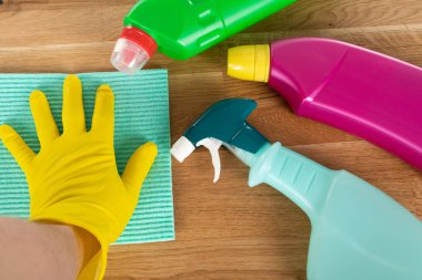 Ahşap arka planda renkli temizlik malzemeleri ve araçlarının resmi