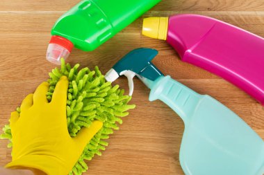 Ahşap arka planda renkli temizlik malzemeleri ve araçlarının resmi