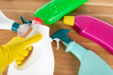 Ahşap arka planda renkli temizlik malzemeleri ve araçlarının resmi