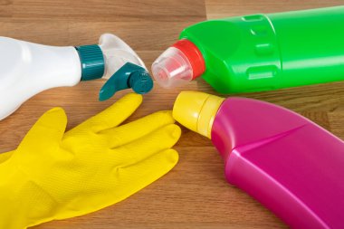 Ahşap arka planda renkli temizlik malzemeleri ve araçlarının resmi