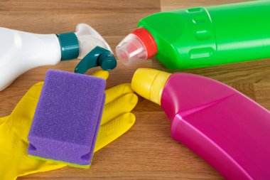 Ahşap arka planda renkli temizlik malzemeleri ve araçlarının resmi