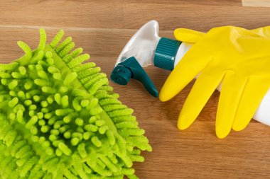 Ahşap arka planda renkli temizlik malzemelerinin resmi