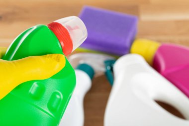 Ahşap arka planda renkli temizlik malzemeleri ve araçlarının resmi