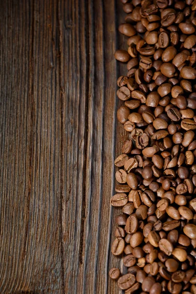Kaffebönor på skrivbord trä — Stockfoto