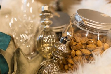 İçinde badem kavanozu, Noel süslemeleri ve şampanya bardakları olan lüks bir Noel paketi.