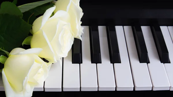 Ramo de rosas blancas en el piano. Flores en un instrumento musical. Cumpleaños, 8 de marzo, día internacional de la mujer, 14 de febrero, día de San Valentín, día de la madre, día de la flor. Tarjeta, regalo, romance, amor —  Fotos de Stock