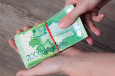 Bir tomar parayı elastik bir bantla tutan eller. Tenge Kzt. Kazakistan 'ın ulusal para birimi, Kz. Değişim oranı. Ekonomi, kalkınma, iş, banka, komisyoncu. BanknotName