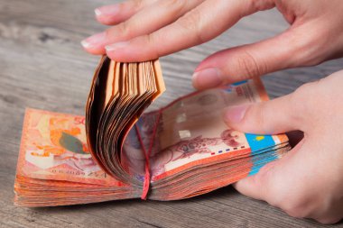 Bir tomar parayı elastik bir bantla tutan eller. Tenge Kzt. Kazakistan 'ın ulusal para birimi, Kz. Değişim oranı. Ekonomi, kalkınma, iş, banka, komisyoncu. BanknotName