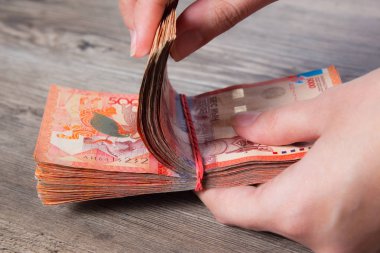 Bir tomar parayı elastik bir bantla tutan eller. Tenge Kzt. Kazakistan 'ın ulusal para birimi, Kz. Değişim oranı. Ekonomi, kalkınma, iş, banka, komisyoncu. BanknotName