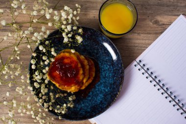 Güzel bir kahvaltı. Reçelli krep ve portakal suyu. Çiçekler ve şık yemekler. Boş sayfaları olan bir günlük. Sağlıklı bir yaşam tarzı. Düz yatıyordu. Lüks dekor.