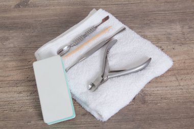 Beyaz bir havluda manikür için bir takım aletler. Tırnak bakımı, prosedür, manikür salonu. Cımbız, tel kesici, satıcı, portakal ağacı sopası, makas, tırnak törpüsü. Pedikür, tırnak eti çıkarma. Evde bakım, Spa, 