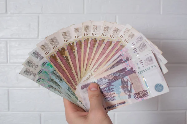 Hand holding a fan of money. Rubles, Russia. Banknote, currency, Bank, economy, business. Salary, loan, prize, prize stash