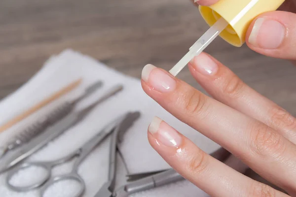 Apply oil to the cuticle. Manicure, nail care. Nail salon, procedure, SPA. Home nail care. Manicure tools. Beauty, lifestyle