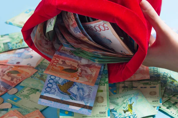 Tenteleri torbadan boşalt. Kazakistan, Kz, Kzt. Kırmızı çantada çok para var. Ulusal para birimi, banknot. Banka, finans, ekonomi, enflasyon. Servet, sermaye, yatırım.