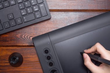 El bir grafik tabletine çiziyor. Serbest çalışan, tasarımcı, çizer. Teknoloji, uzaktan kumanda, dış kaynak kullanımı. Grafik tableti için eldiven ve kalem. Grafik tasarımcısı dijital tablet üzerinde çalışıyor. Proje