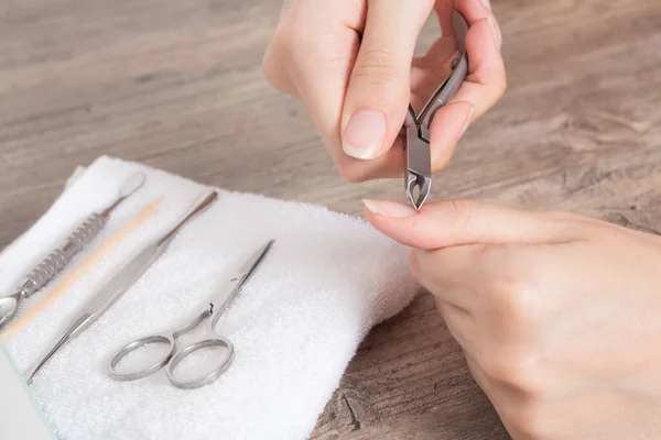 A woman does a manicure at home. Manicure tools. Edged manicure. Cut, wound on the finger, blood. Dangerous manicure. Home care, Spa, beauty. Nail salon