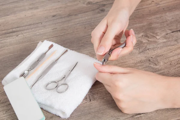 A woman does a manicure at home. Manicure tools. Edged manicure. Cut, wound on the finger, blood. Dangerous manicure. Home care, Spa, beauty. Nail salon