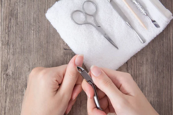 A woman does a manicure at home. Manicure tools. Edged manicure. Cut, wound on the finger, blood. Dangerous manicure. Home care, Spa, beauty. Nail salon