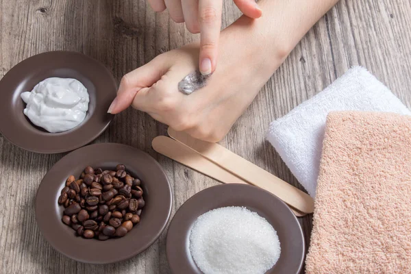 A woman applies a natural scrub to the skin. Homemade scrub made of sugar, salt, cream and coffee. Beauty, Spa, skin care, aromatherapy. Moisturizing, peeling, exfoliation