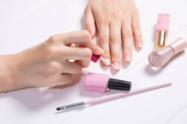 Manikür. Bir kadın tırnaklarını boyuyor. Kız oje sürüyor. Fransızca, tırnak bakımı. Manikür salonu, prosedür, SPA. Evde tırnak bakımı. Manikür aletleri. Güzellik, tırnak sanatı, ihtişam