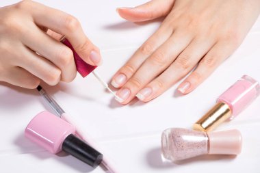 Manikür. Bir kadın tırnaklarını boyuyor. Kız oje sürüyor. Fransızca, tırnak bakımı. Manikür salonu, prosedür, SPA. Evde tırnak bakımı. Manikür aletleri. Güzellik, tırnak sanatı, ihtişam