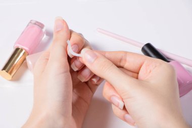 Manicure. A woman glues stickers on her nails for French manicure. The girl applies nail Polish. Nail salon, procedure, SPA. Home nail care. Manicure tools. Beauty, nail art, Glamour. clipart
